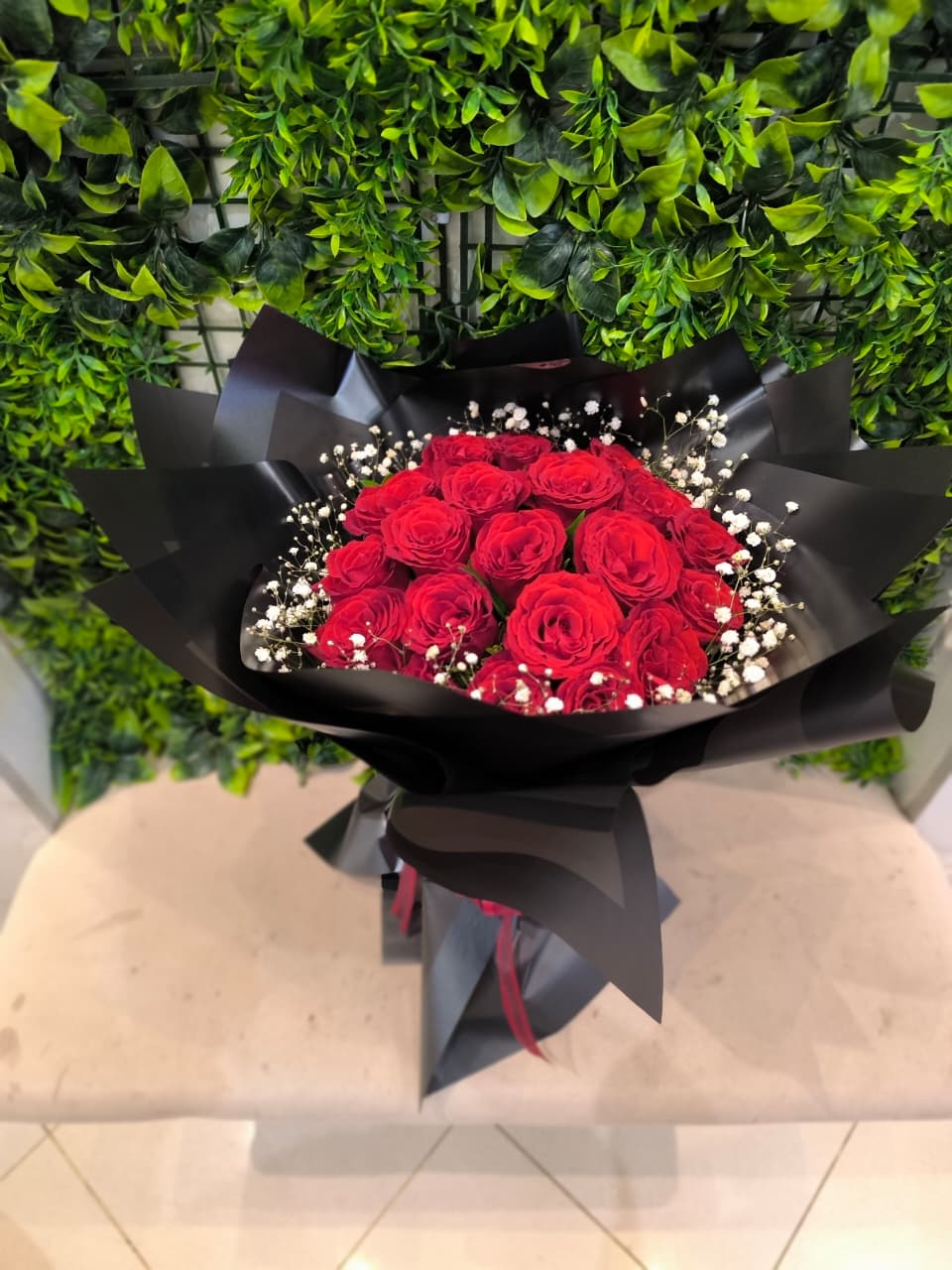 Bouquet rond rouge avec emballage noir et gypsophile